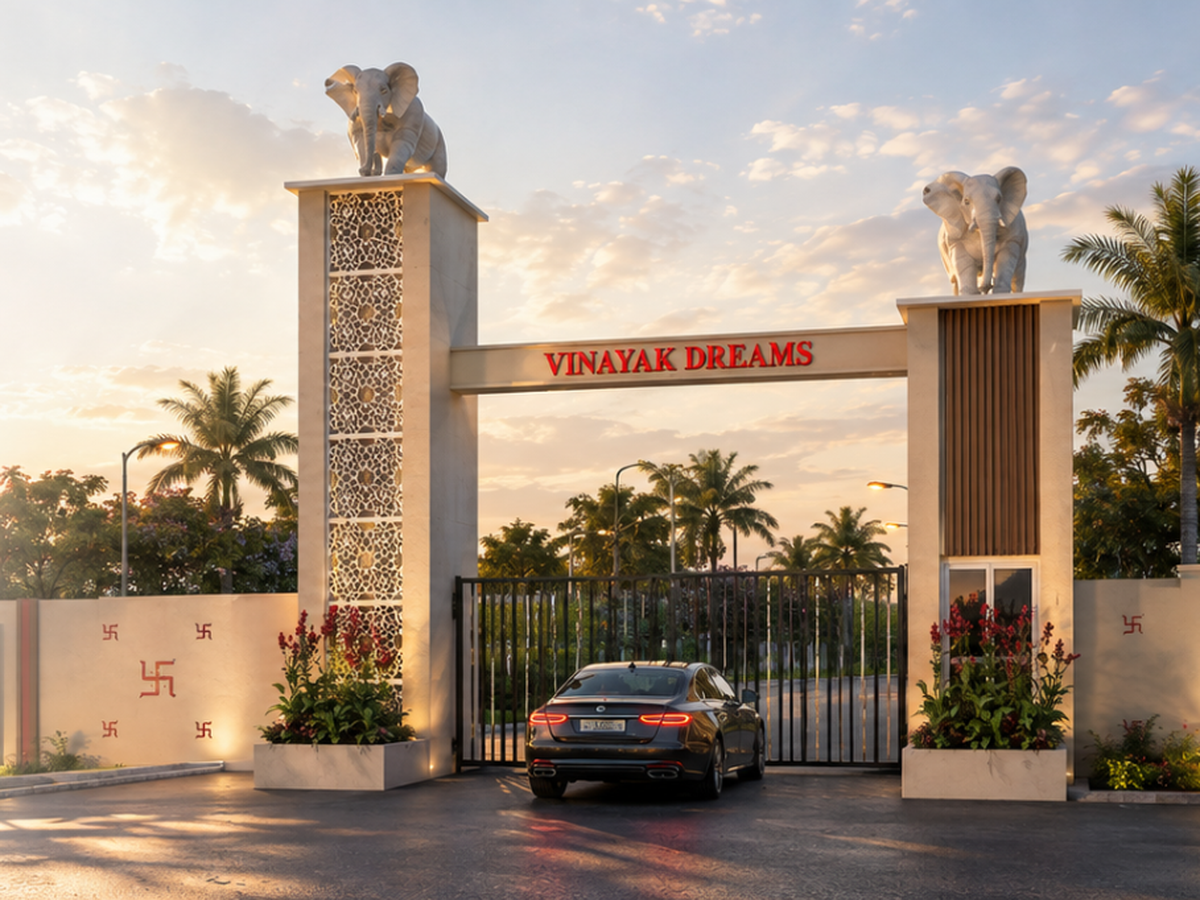 Elephant-crowned stone pillars at the Vinayak Dreams entrance gate